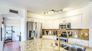A modern kitchen with white cabinets, granite countertops, stainless steel appliances, and a built-in oven. - Outdoor Oasis! Family-Friendly North Phoenix Home (Phoenix)