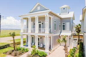 Enjoy a scenic view from the upper-level balcony, featuring a covered porch with seating for relaxation.