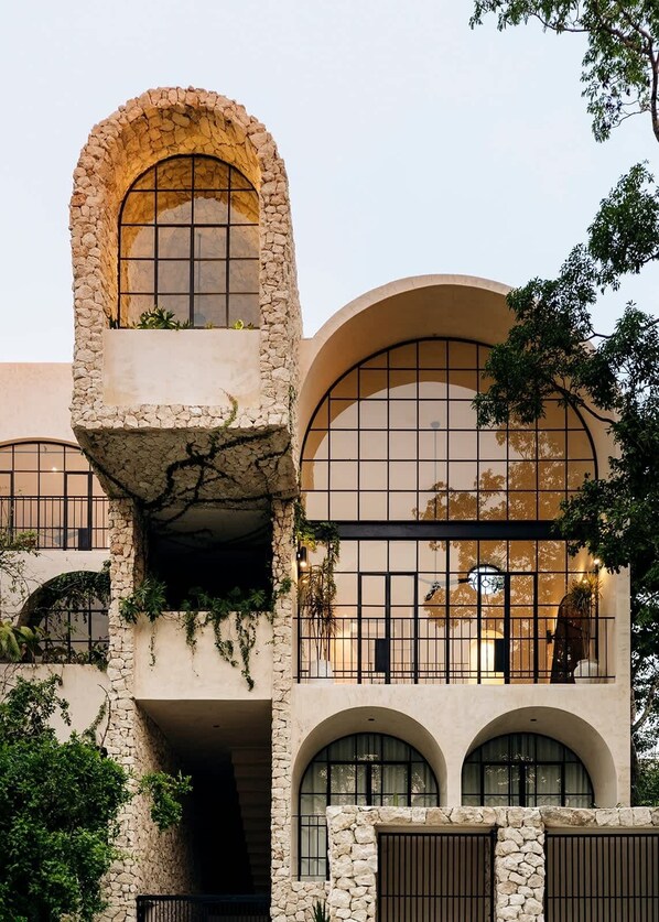 Un bĂątiment dotĂ© dâune architecture originale, caractĂ©risĂ©e par des fenĂȘtres en arc et des murs en pierre.