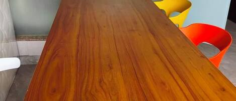 A wooden table with a dark finish, surrounded by chairs.