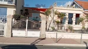 Un immeuble doté d’une entrée fermée par un portail, d’un balcon et d’un toit rouge.