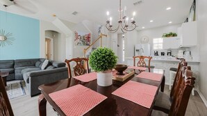 A dining area with a wooden table, red placemats, and a potted plant. - HOME SWEET HOME ! COMFY 4 BED 4 BATH SLEEPING 10  PRIVATE TUSCAN HILLS COMMUNITY (Davenport)