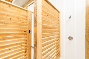 A wooden door with horizontal slats and a metallic handle. - Beachfront | Heated Pool | Hot Tub | Fenced Yard with Game Area (Crystal Beach)