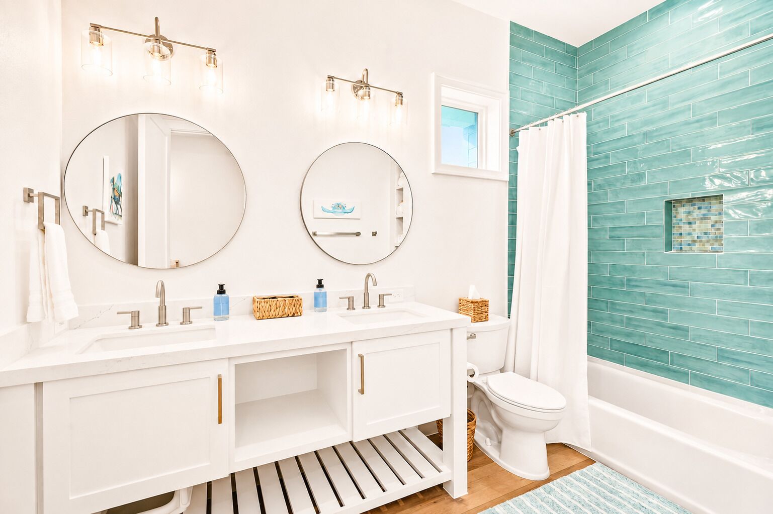 A bathroom with two sinks, a toilet, and a shower area.