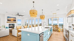 A spacious kitchen with a large island, wooden flooring, and a view of the ocean. - Beachfront | Heated Pool | Hot Tub | Fenced Yard with Game Area (Crystal Beach)