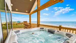 A hot tub with a wooden deck and a view of the ocean. - Beachfront | Heated Pool | Hot Tub | Fenced Yard with Game Area (Crystal Beach)