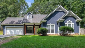 A two-story house with a garage, a front porch, and a well-maintained lawn. - Breath of Fresh Air DT Atlanta (Atlanta)