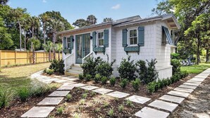 A single-story house with a front porch, a small staircase, and a garden with a stone pathway. - 16 29th Avenue Isle of Palms Group Retreat (Isle of Palms)