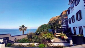 Un bâtiment situé sur la côte, offrant une vue sur l’océan et une falaise.