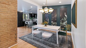 Un comedor moderno con una mesa blanca, sillas de vidrio transparente y una alfombra gris.