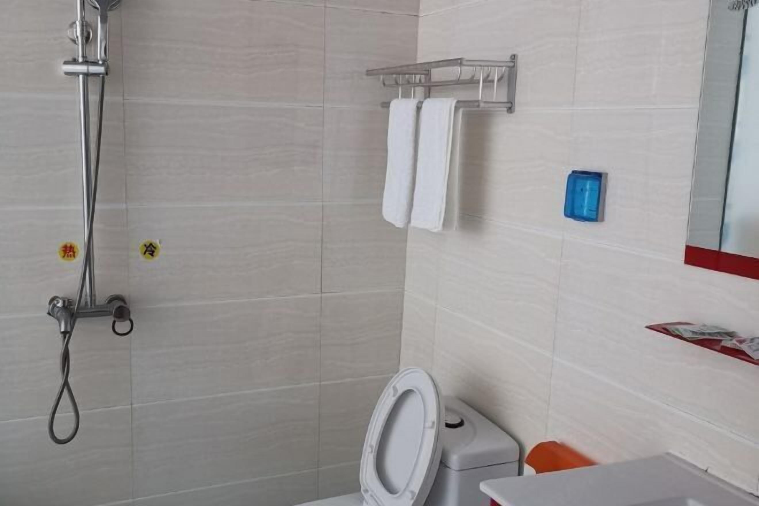 Une salle de bain avec une douche, des toilettes et un lavabo.