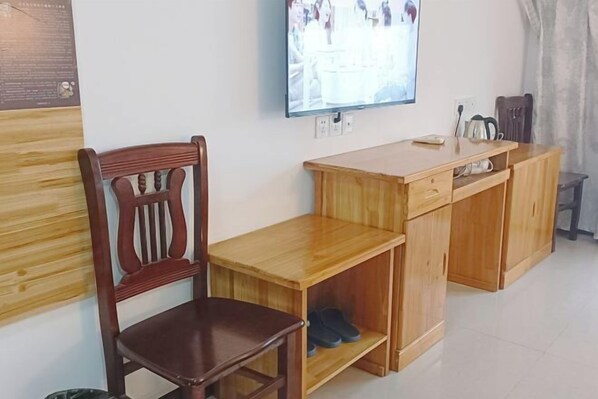 A wooden desk with a chair, a television mounted on the wall, and a small cabinet with shoes. - Binghe Courtyard Mountain Forest Creekside Vacation Boutique Stay (Tiantangzhai Scenic Area) (Jinzhai)