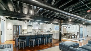 Une cuisine moderne dotée d’un îlot central, de tabourets de bar et d’un coin repas avec une table et des chaises.