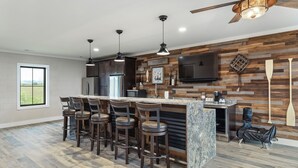 Une cuisine moderne avec un coin bar, des éléments décoratifs en bois et une grande fenêtre.