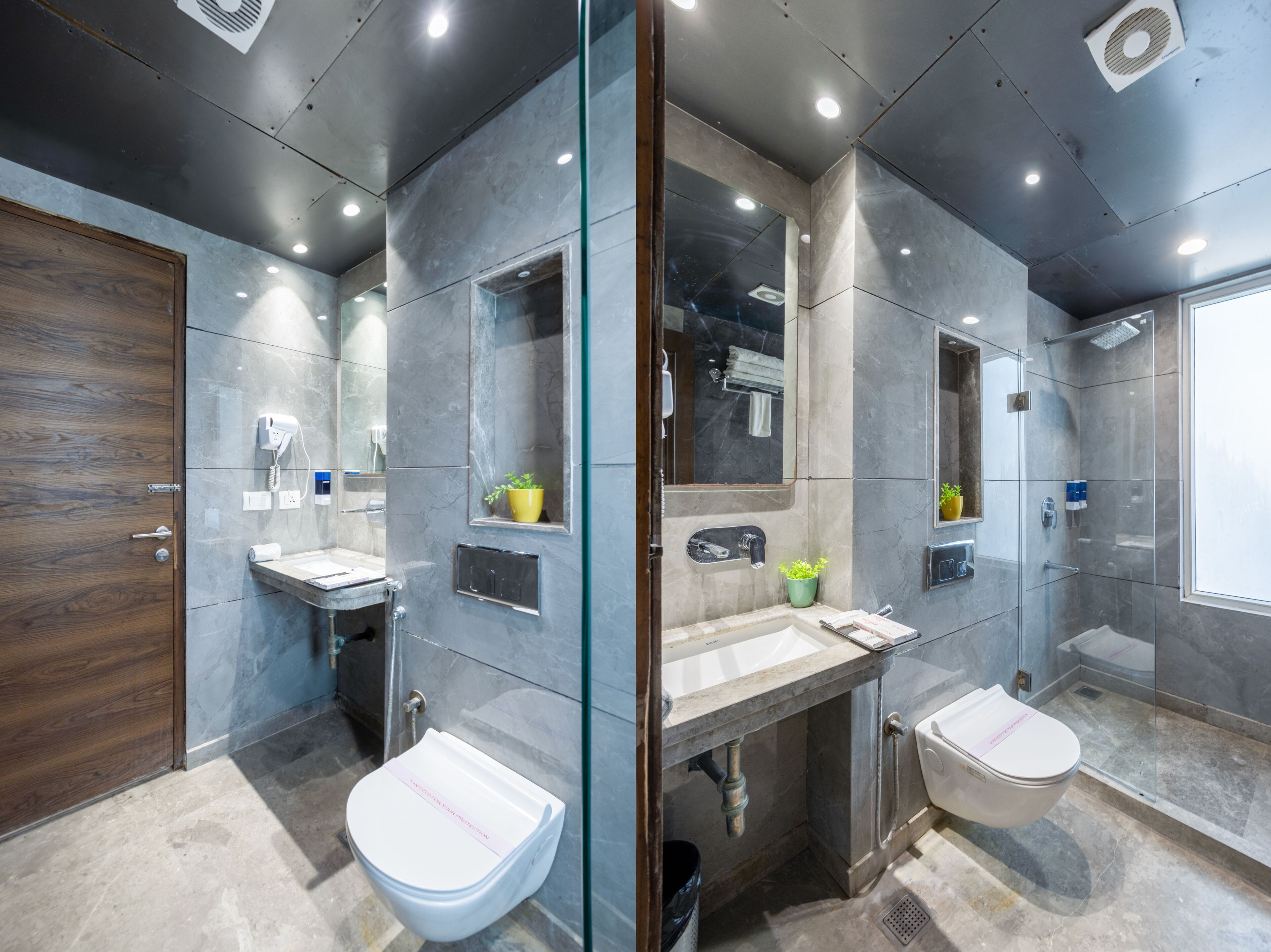 A modern bathroom with a wooden door, a glass shower enclosure, and a marble-tiled floor.