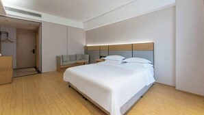 A modern hotel room with a large bed, a bedside table, a chair, and a wardrobe. - HanTing Hotel (Taizhou Sanmen) (Sanmen)