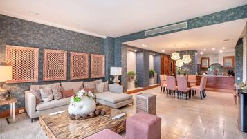 A modern living room with a sofa, coffee table, and dining area with chairs.
