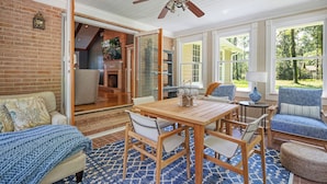 Un salon chaleureux avec une table en bois, des chaises et un tapis bleu à motifs.