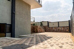 Stroll through the serene outdoor space, featuring a paved walkway leading to a gated entrance.