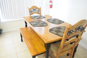 Enjoy meals in this cozy dining area with a wooden table, bench, and comfortable chairs.