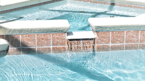 A hot tub with tiled walls and a clear blue water surface. - 2551 Oneida Grantham (Kissimmee)