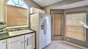 A kitchen with a built-in refrigerator, a double sink, and a window with blinds. - 4 Bed Villa in Kissimmee, Orlando (Kissimmee)