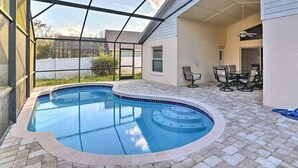A swimming pool with a glass enclosure, a patio area with outdoor furniture, and a view of the surrounding neighborhood. - 4 Bed Villa in Kissimmee, Orlando (Kissimmee)