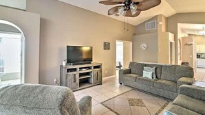 A spacious living room with a large TV, a ceiling fan, and a sofa. - 4 Bed Villa in Kissimmee, Orlando (Kissimmee)