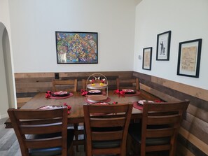 A dining area with a wooden table, chairs, and a Mickey Mouse-themed centerpiece. - 8054 Hidden Gem (Kissimmee)
