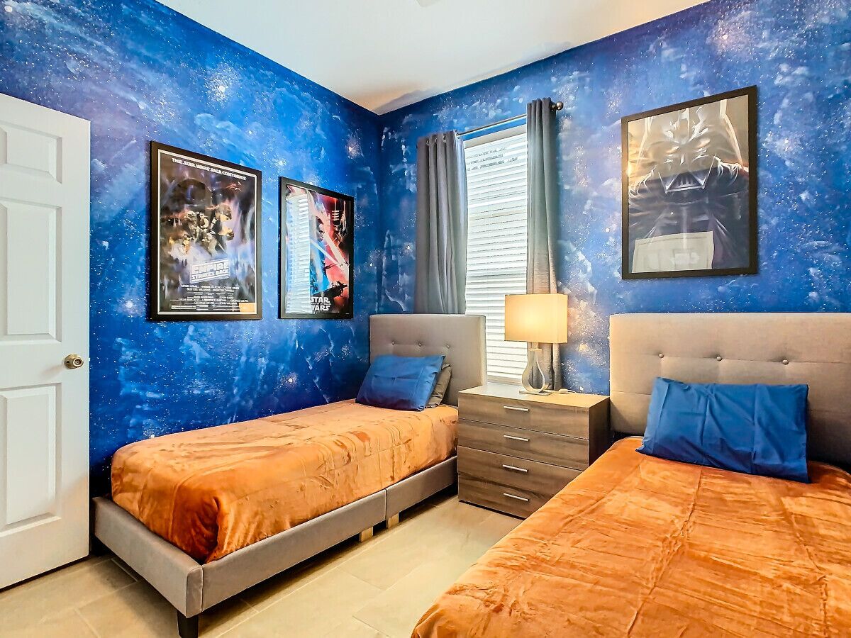 A bedroom with two beds, a dresser, and a nightstand.