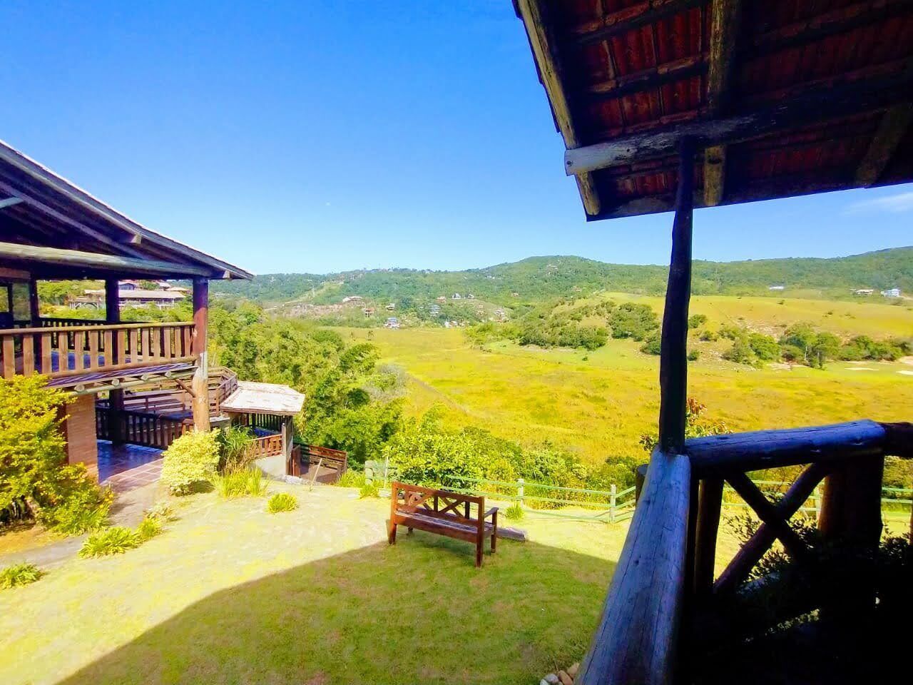 A wooden building with a balcony overlooking a green landscape.