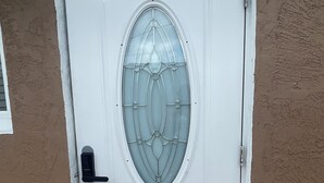 A white door with a glass panel and a black handle. - Luxury Studio with Private Entrance Near Hard Rock Stadium. (Miami Gardens)