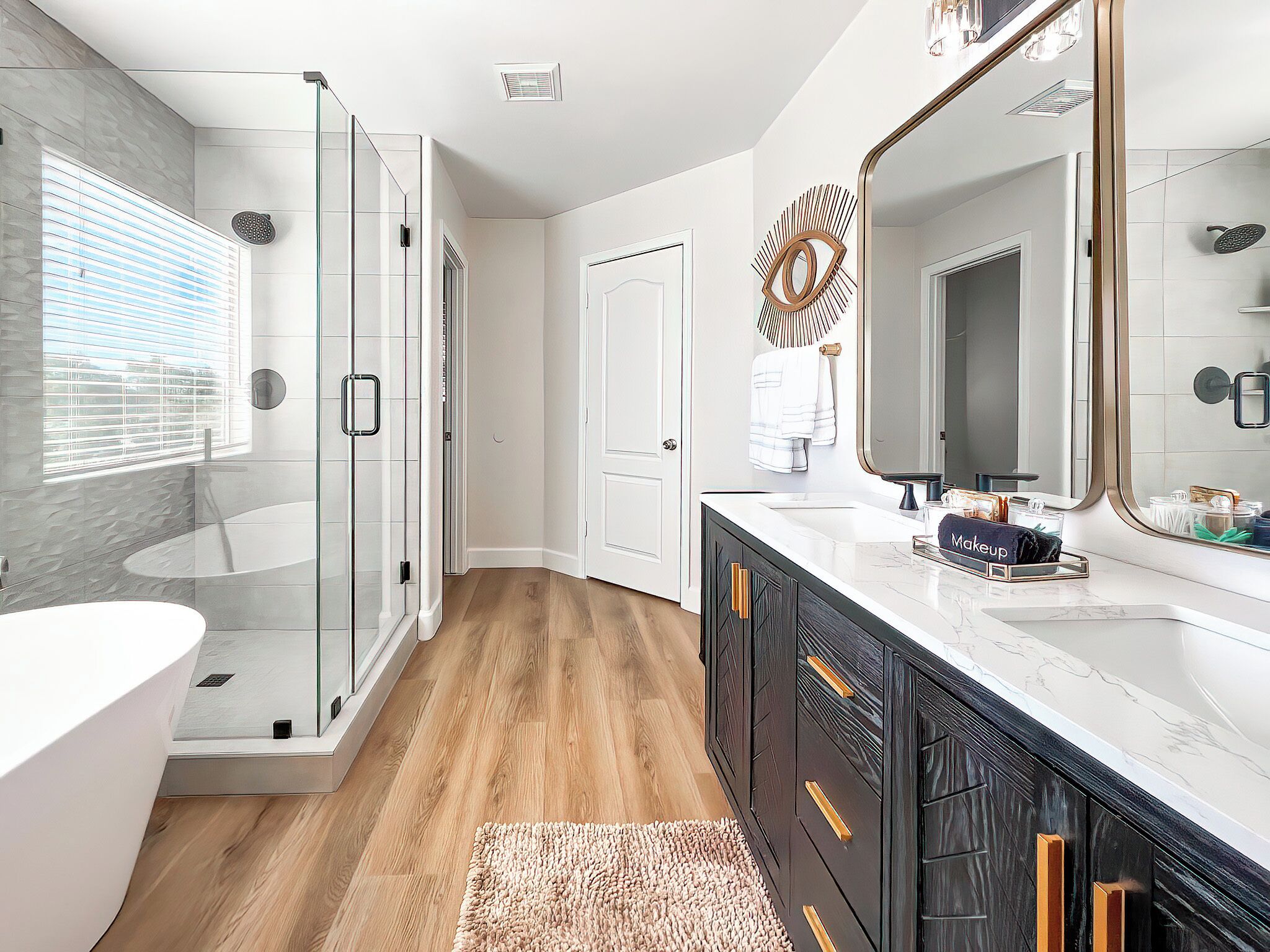 A modern bathroom with a glass shower enclosure, a white sink, and a large mirror.