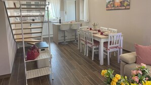 A modern kitchen with a wooden island, white bar stools, and a dining table set for four. - Penthouse 800: elegant and refined apartment located in a historic hamlet (Castiglion Fosco)