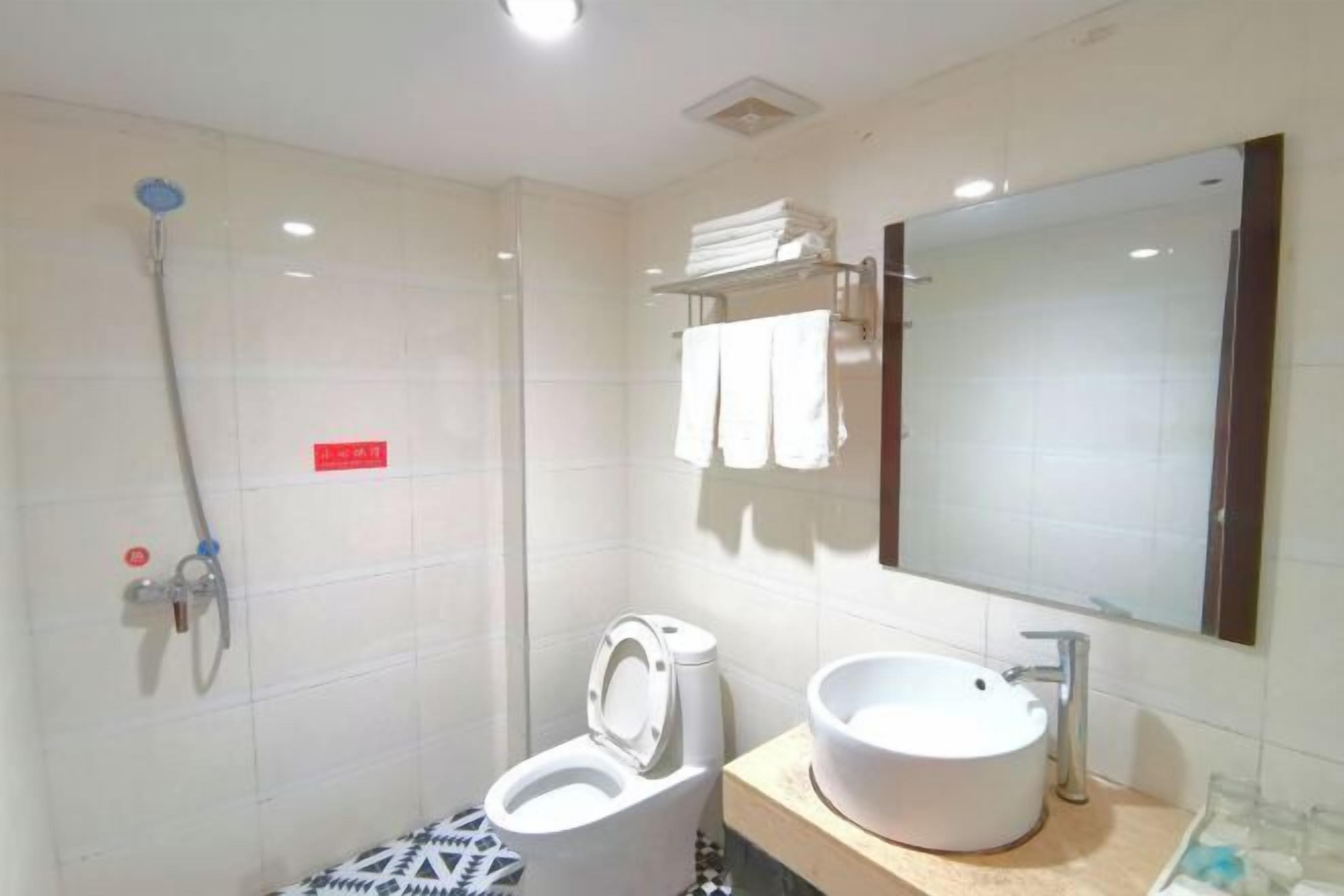 A bathroom with a toilet, bidet, sink, and a mirror.