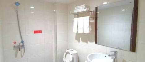 A bathroom with a toilet, bidet, sink, and a mirror.