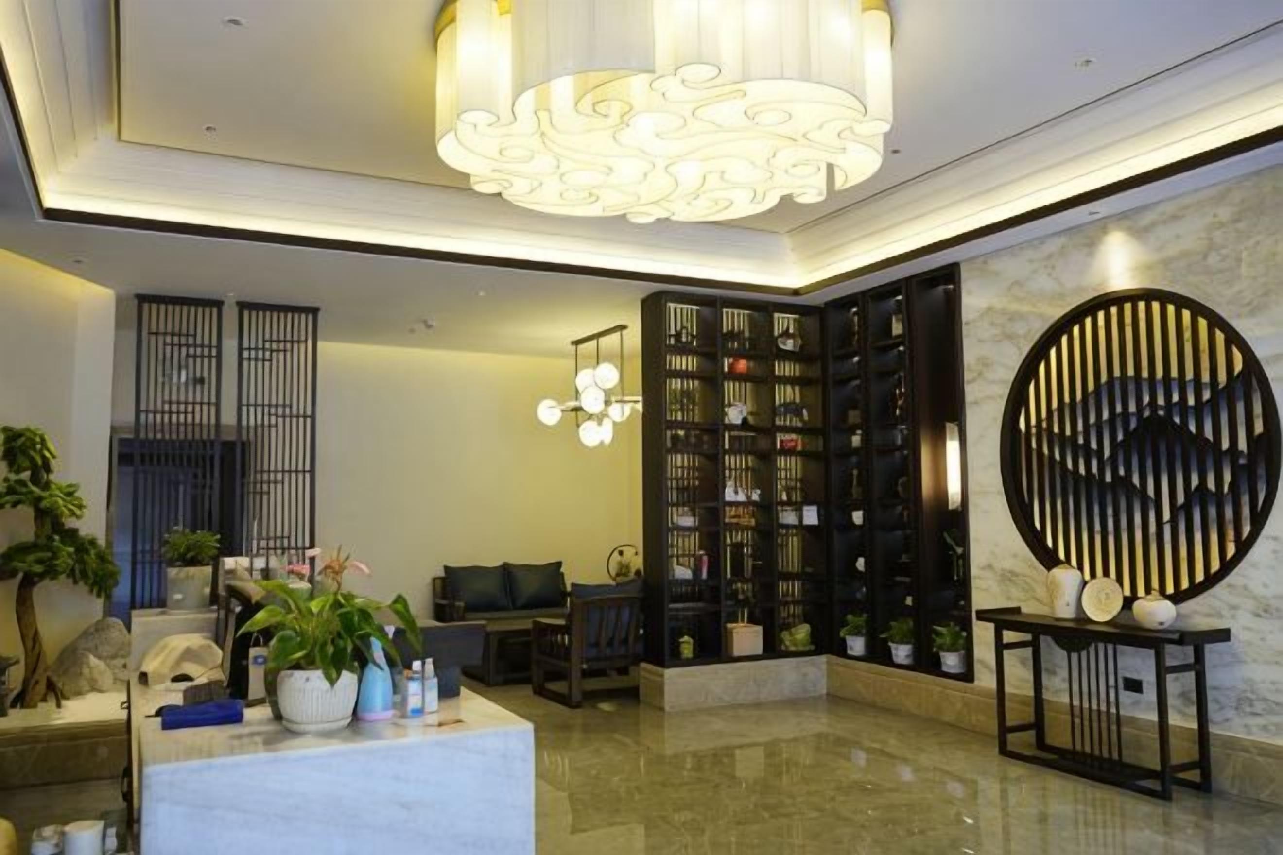 A lobby with a reception desk, seating area, and a wine rack.