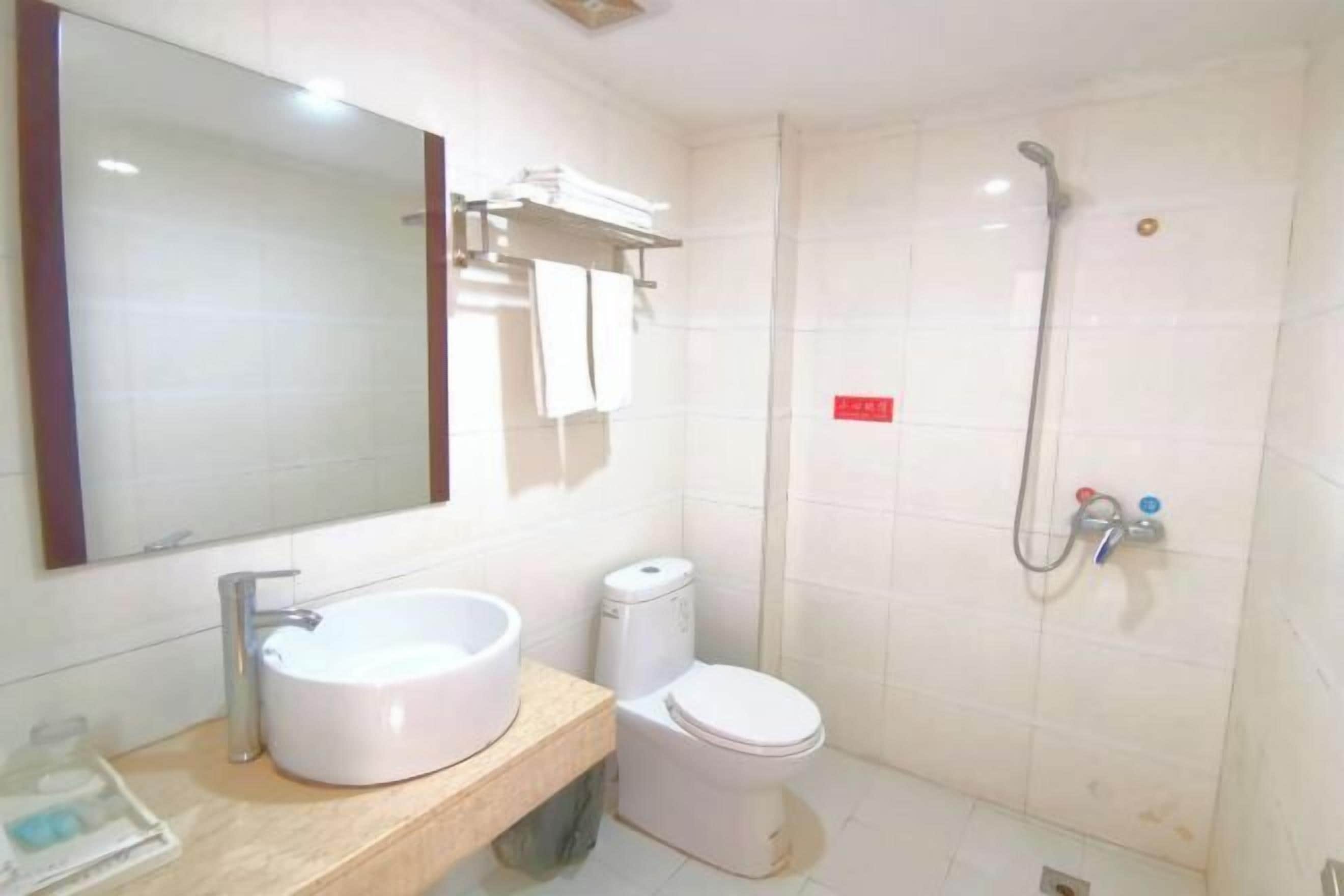 Un baño con lavamanos, inodoro y ducha.