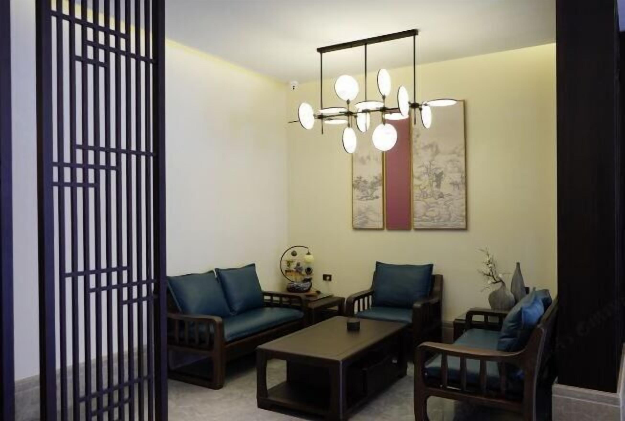 A living room with two sofas, a coffee table, and a hanging light fixture.