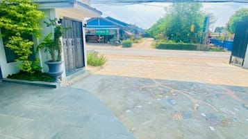 A residential property with a paved driveway, a gated entrance, and a small garden area.