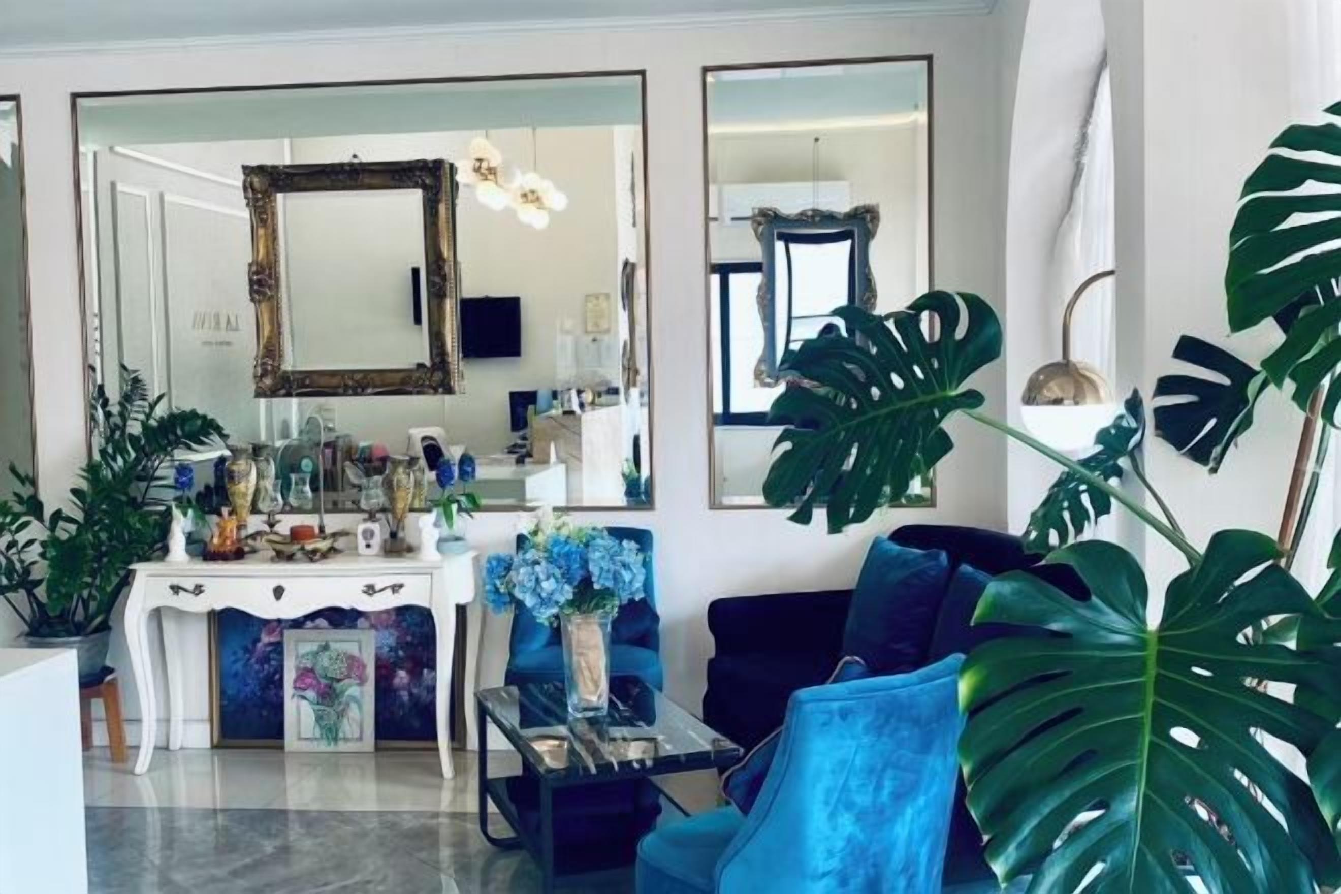 A living room with a sofa, a coffee table, a dining table, and a large plant.