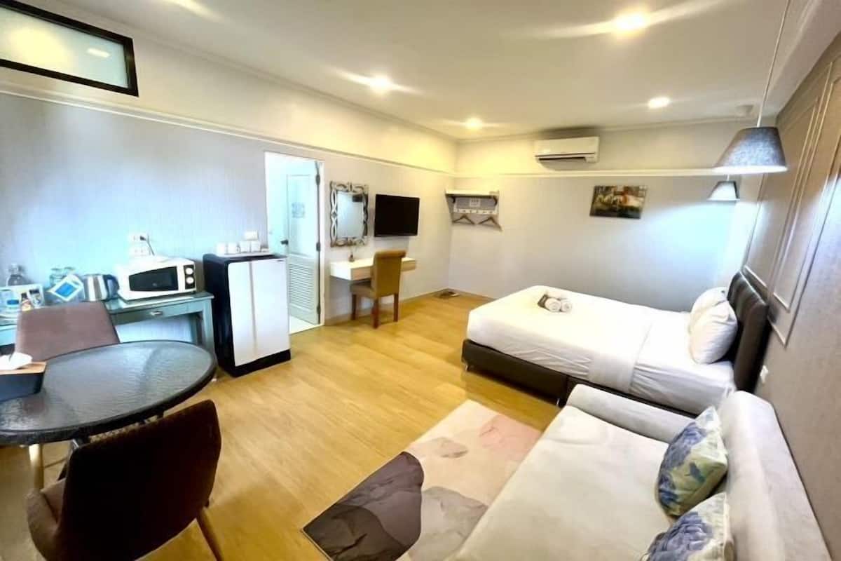 Une chambre d’hôtel comprenant un lit, un bureau, une chaise, une petite table et un téléviseur.