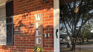 A brick house with a 'WELCOME' sign, a mailbox, and a number '2702' on the door. - Charming Brand NEW  3B/2bathroom house closed by to all shopping and MUSC (Florence)