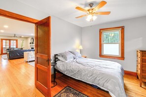A bedroom with a bed, a wooden dresser, a window, and a ceiling fan. - Charming Damascus Retreat w/ Deck & Creek Views! (Damascus)