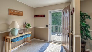 A hallway with a wooden bench, a lamp, a welcome sign, and a door leading to a balcony. - 2 Mi to Blue Ridge Pkwy! Mtn-View Sparta Retreat (Sparta)