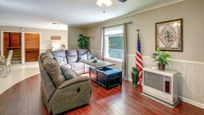 A living room with a sectional sofa, a coffee table, a ceiling fan, a radiator, and a large window with curtains. - 2 Mi to Blue Ridge Pkwy! Mtn-View Sparta Retreat (Sparta)
