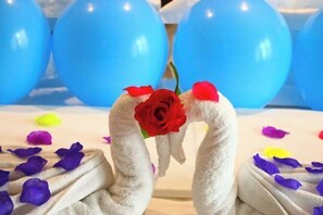 A decorative arrangement with a white fluffy object, a red rose, and scattered flower petals. - Yoyo Hotel (Zhongshan Bus Terminal) (Zhongshan)