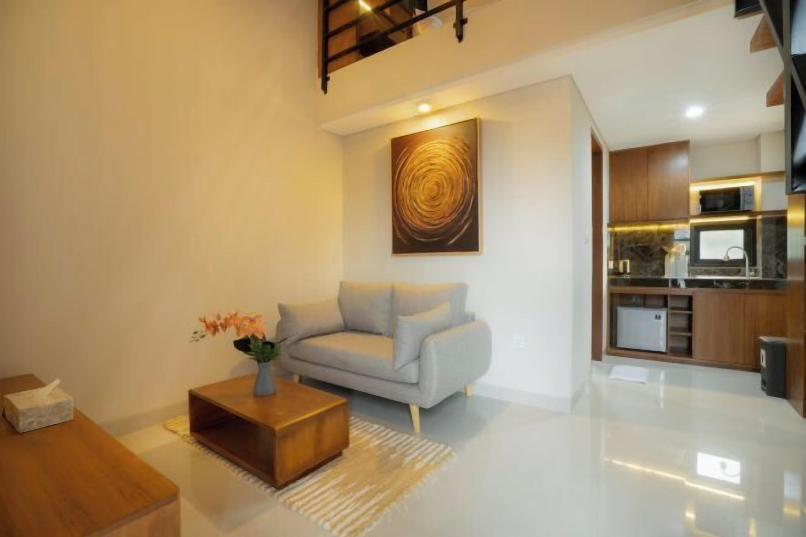 A modern living room with a sofa, coffee table, and a painting on the wall.