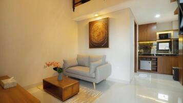 A modern living room with a sofa, coffee table, and a painting on the wall.