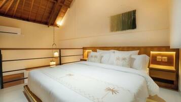 A bedroom with a bed, bedside lamps, a wall-mounted air conditioner, and a ceiling fan.